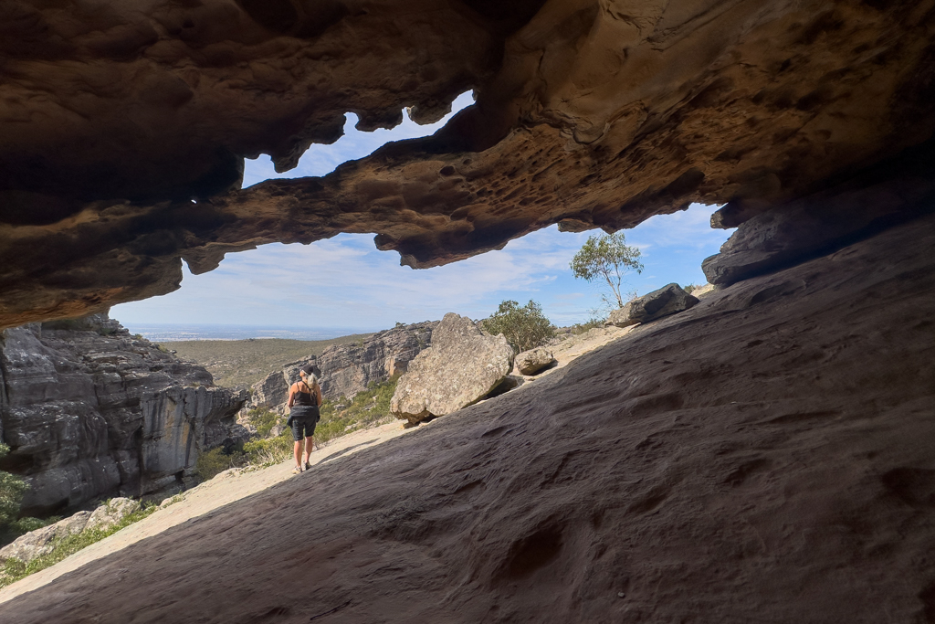 Eine grosse Felsspalte mit einem kleinen Arch (Bogen) Ma schaut sich die Landschaft an...