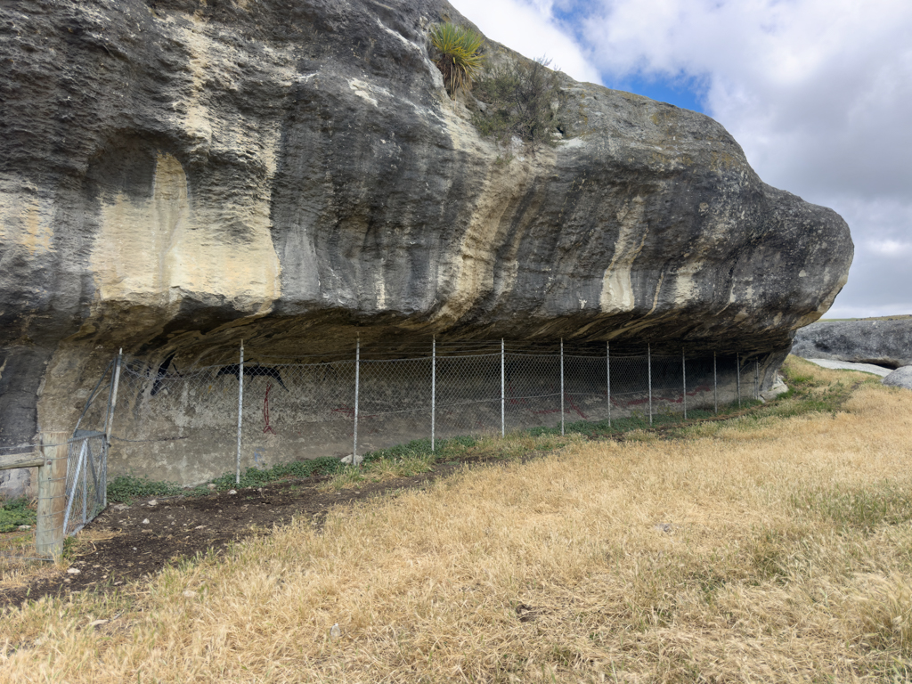 Entlang der geschützten Felswand sehen wir die Maori Felsmalereien