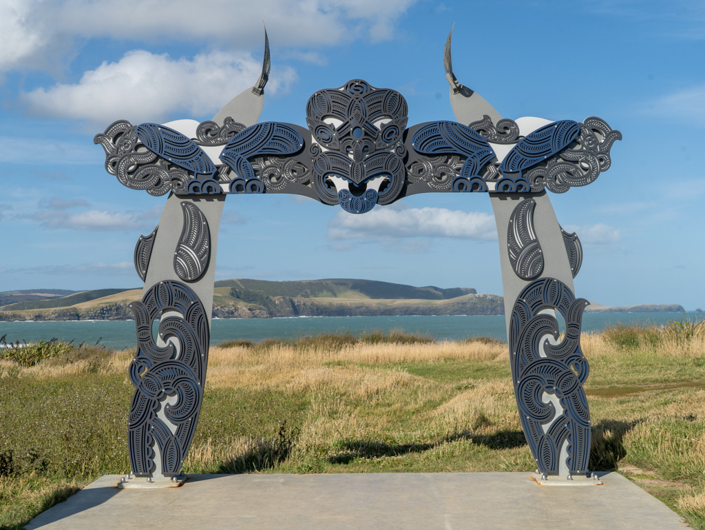 Stylisch moderner Torbogen mit Maori Ornamenten an der Curio Bay