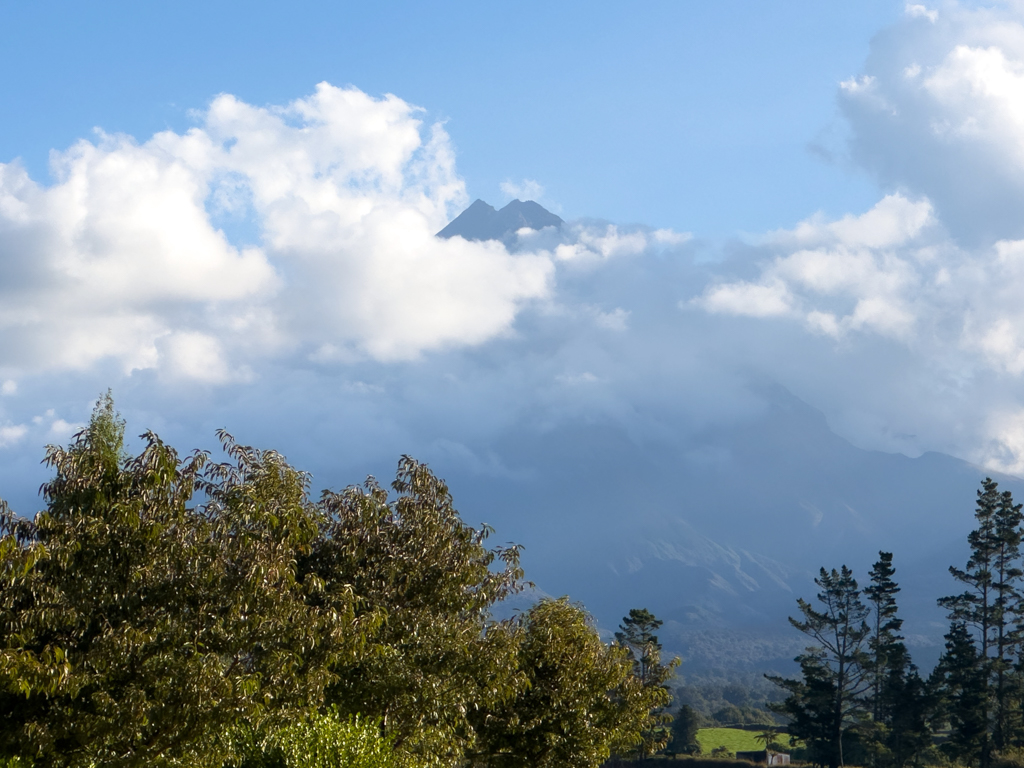Die Wolken geben kurz die Spitze von Te Papakura o Taranaki / Mt. Taranaki frei