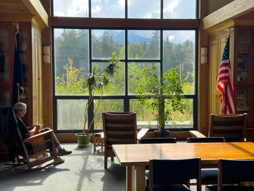 "Wohnzimmer" mit Schaukelstuhl und Panoramafenster in der Bibliothek von Haines