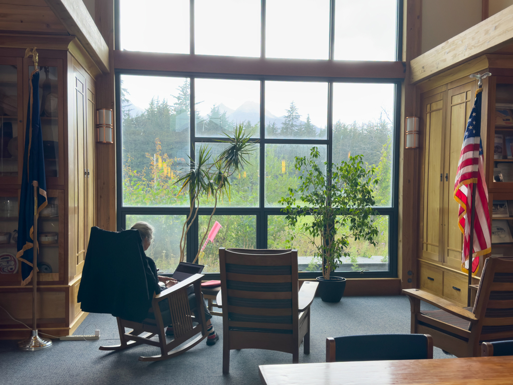 "Wohnzimmer" mit Schaukelstuhl und Panoramafenster in der Bibliothek von Haines