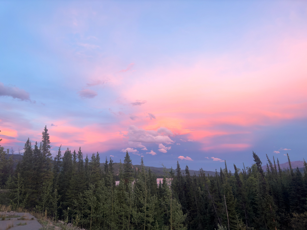 Gegenüber des Abendrots färben sich die Wolken in unzähligen Pink-Tönen