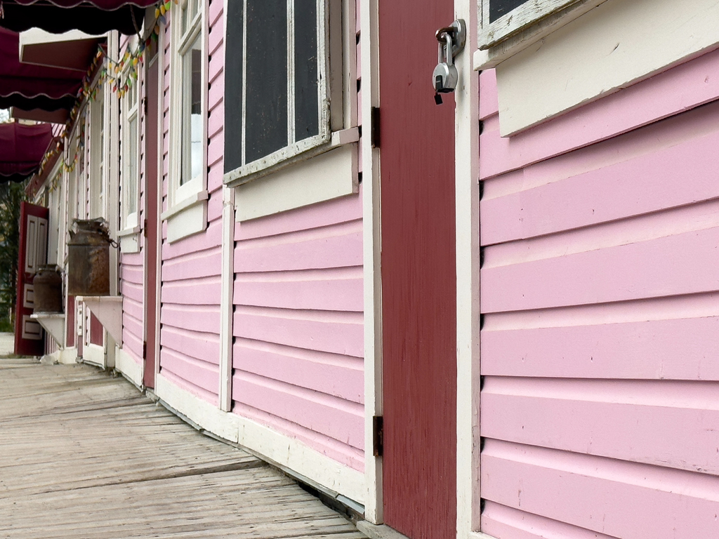 Hölzernes Trottoir und rosa Fassaden in Dawson City