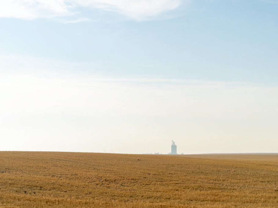 Weite Landschaft mit abgemähten Feld und riesigem Getreidespeicher nach Red Deer