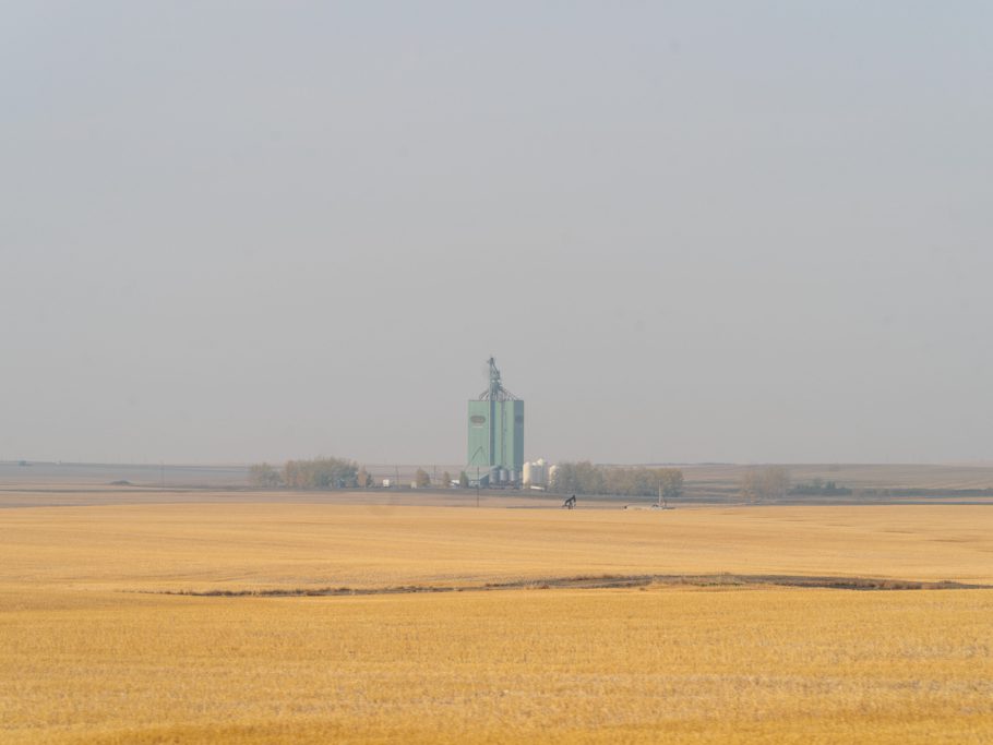 Weite Landschaft mit abgemähten Feld und riesigem Getreidespeicher nach Red Deer