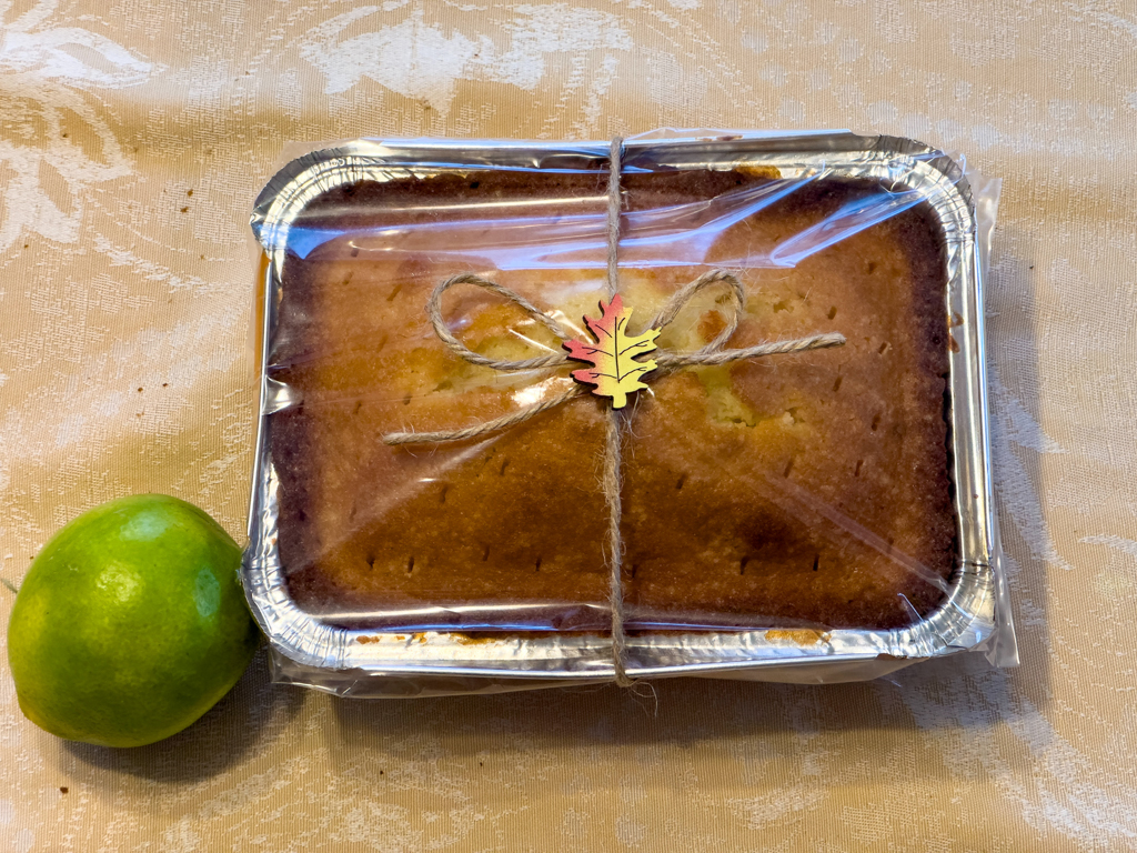 Beschreibung wie aus einem Museumskatalog: Stilleben mit einem Zitronenkuchen und grüner reifer Zitrone.