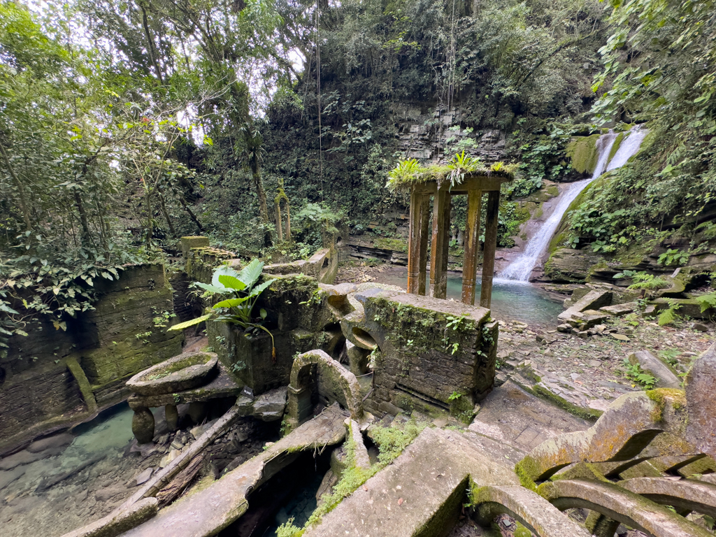 Wasserfall im Hintergrund und Badebecken auf Säulen