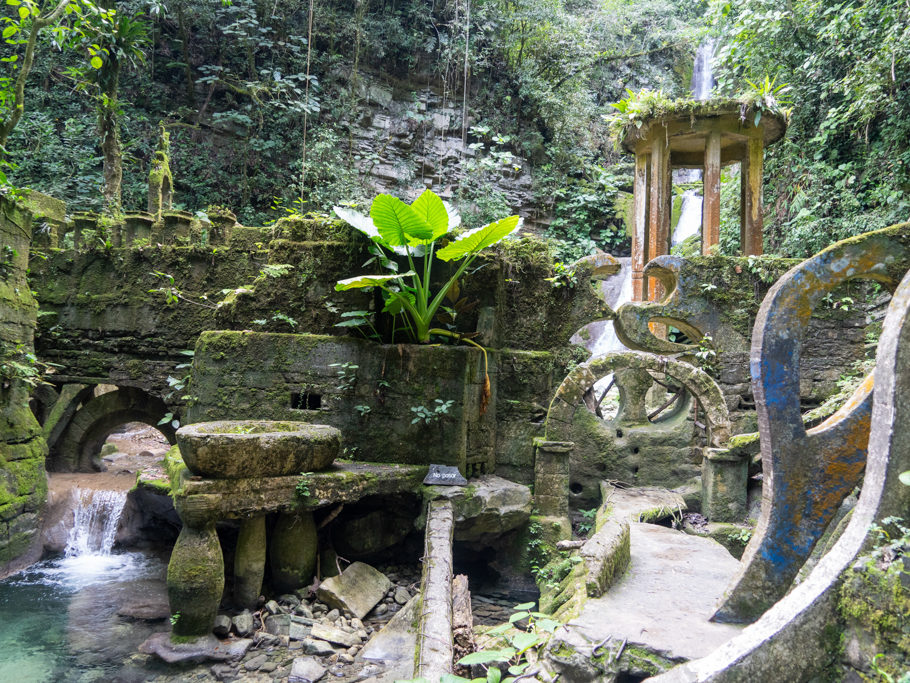 Wasserfall im Hintergrund und Badebecken auf Säulen