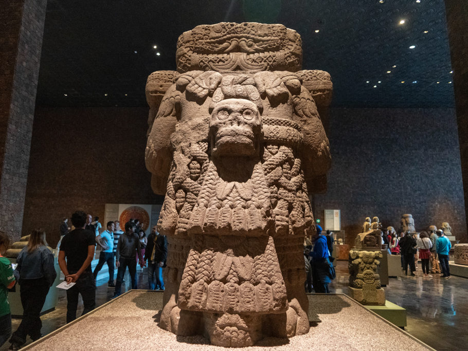 Die Rückseite mit Totenkopf, Adlerfedern und Schlangenkopf zwischen den Füssen einer grossen Steinskulptur