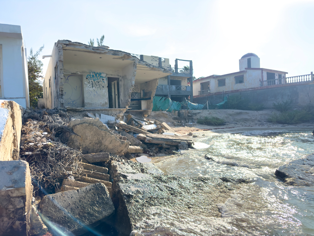 Neben dem Beach Club: Das Meer gibt, das Meer nimmt. Eine vom Meer unterspülte und eingestürzte Hausruine