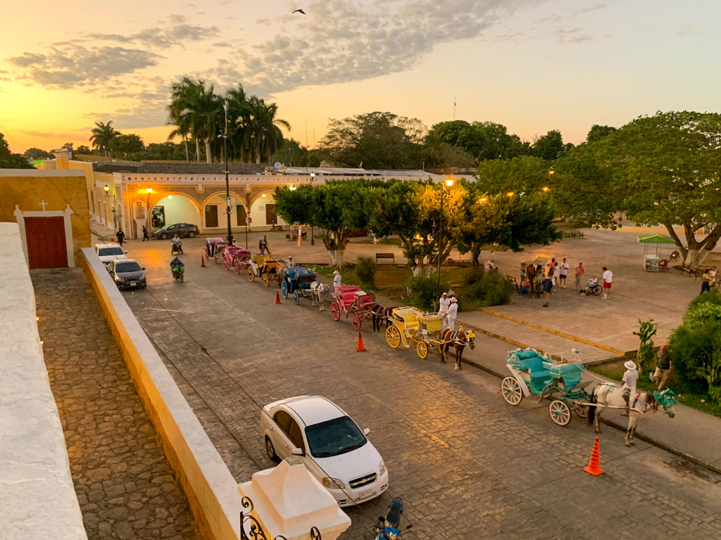 Blick auf den Platz neben dem Konvent in Izamal. Bunte Kutschen warten auf zahlende Kundschaft.