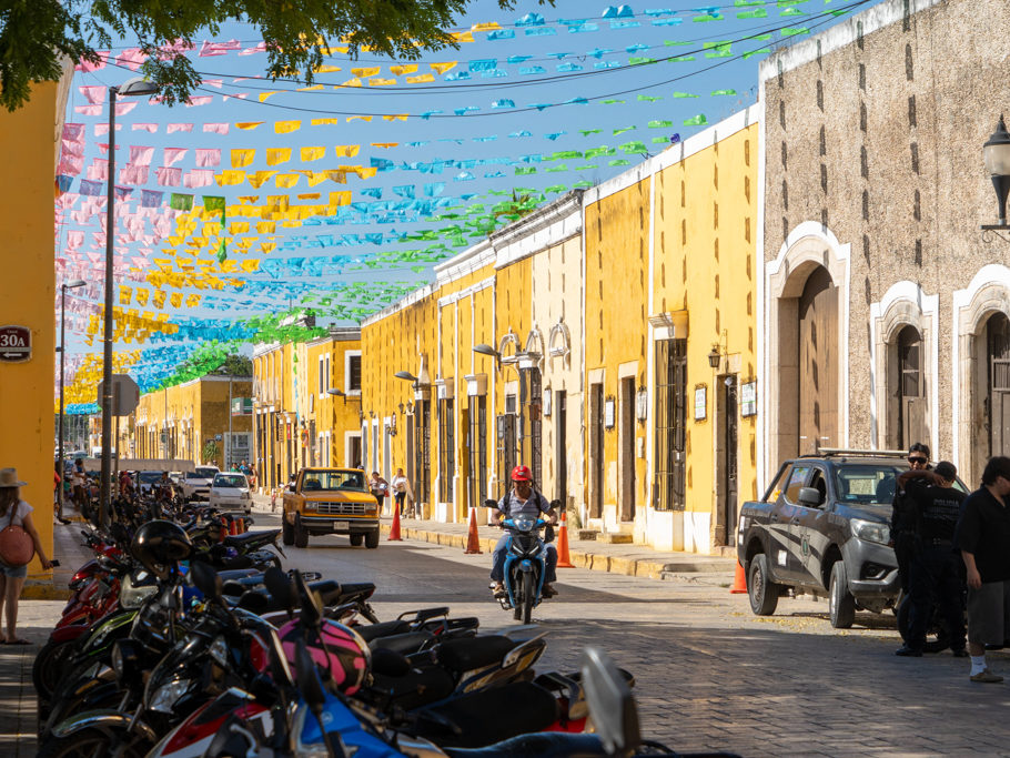 Schattenspiel: Die mit Girladen geschmückten gelben Häuser in der Hauptstrasse zum Zocalo in Izamal
