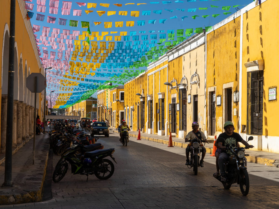 Schattenspiel: Die mit Girladen geschmückten gelben Häuser in der Hauptstrasse zum Zocalo in Izamal