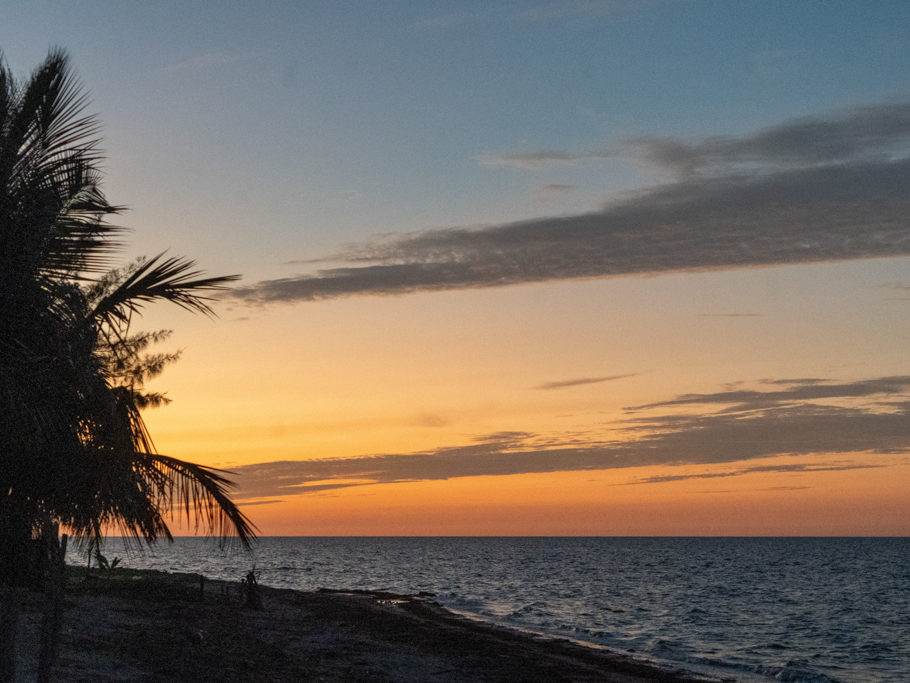 Die kurze Abenddämmerung färbt den Himmel rot. Am Strand von unserem Campground in San Crisanto