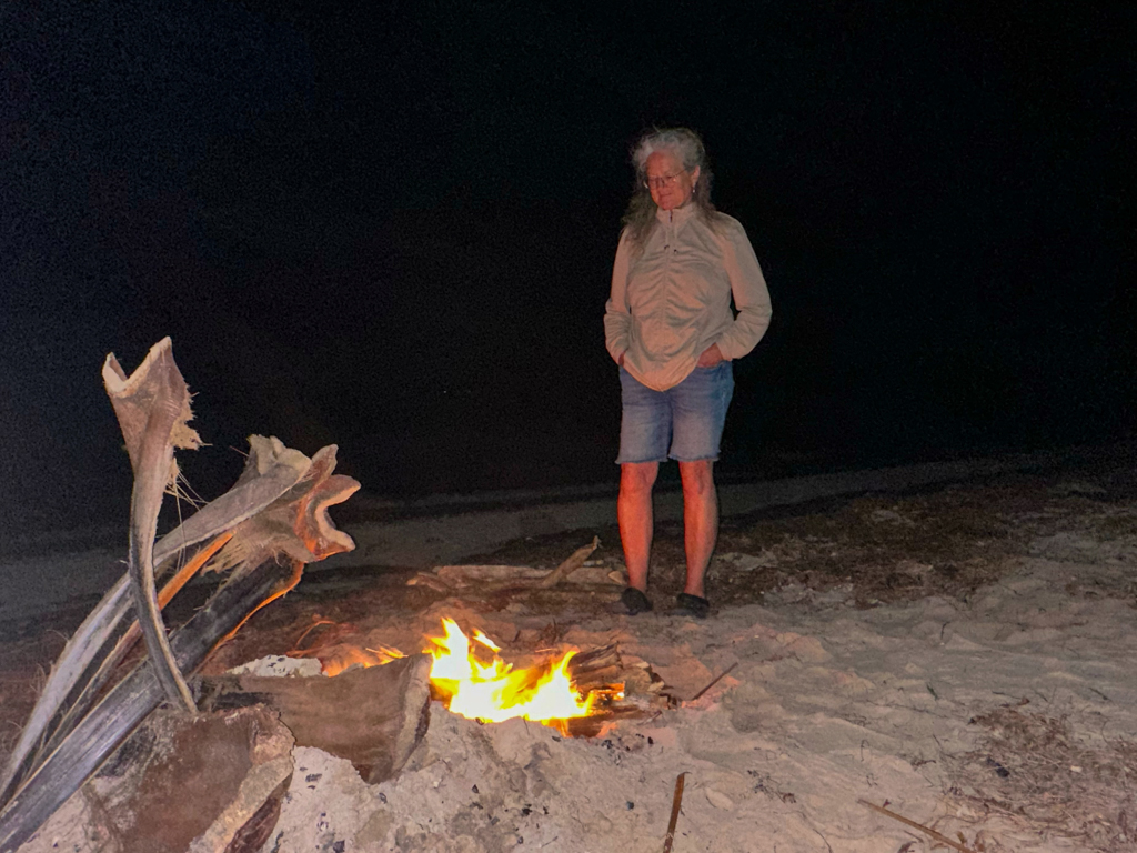 Ma sinniert etwas am Feuer an Dereks Geburtstagsparty am Strand