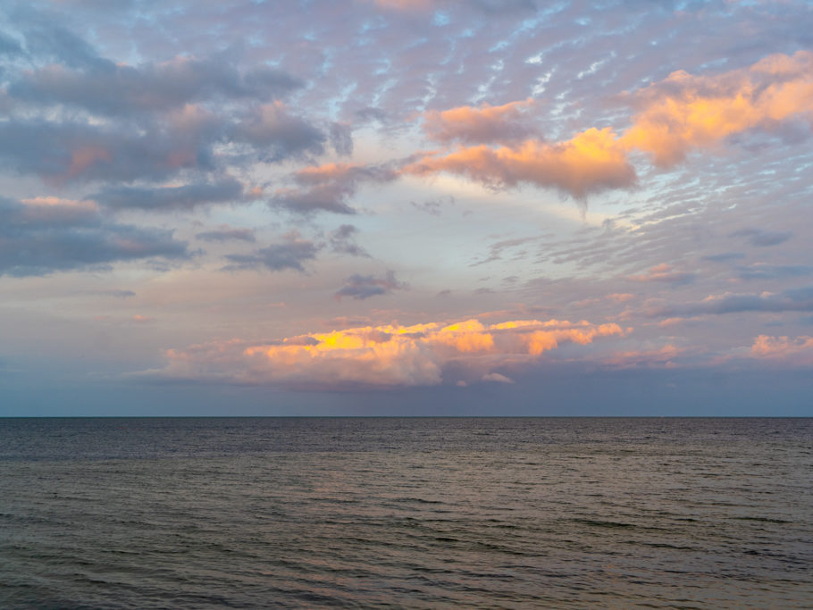 Ein Bild nach William Turner: Dort wo Himmel und Wasser zusammentreffen. Tiefe und noch sonnenbeschienene Wolken und die kleinen Schäfchenwolken dunkeln schon ein.