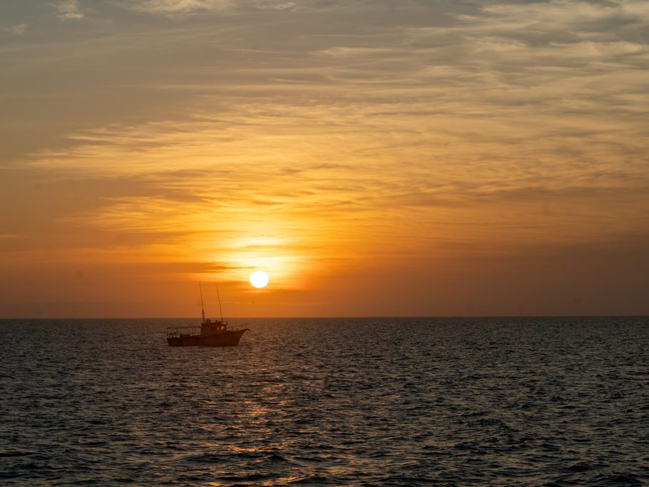 Ein Fischerboot dümpelt im Abendlicht vor Celestun dahin