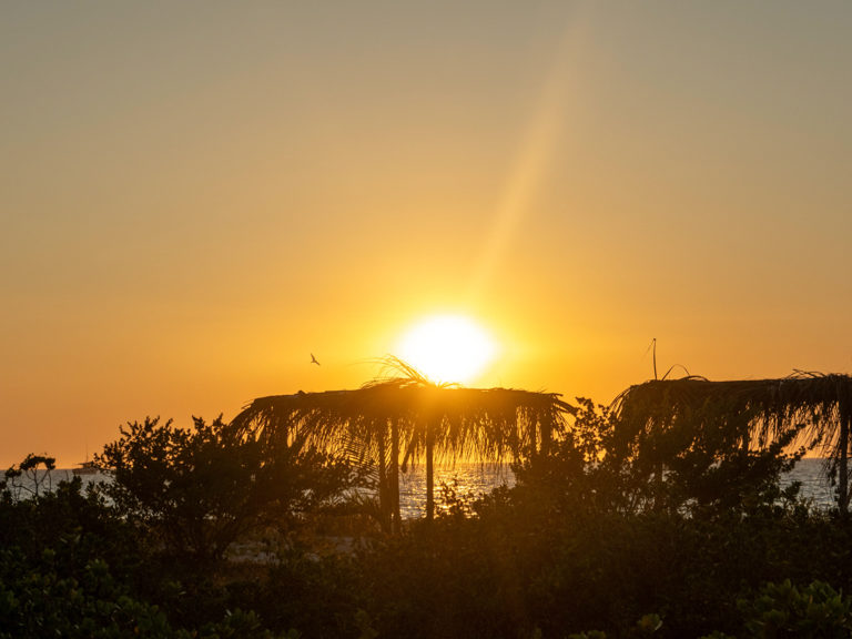 Sonnenuntergang in Celestun am Meer. Mit einsamen Palapas im Vordergrund