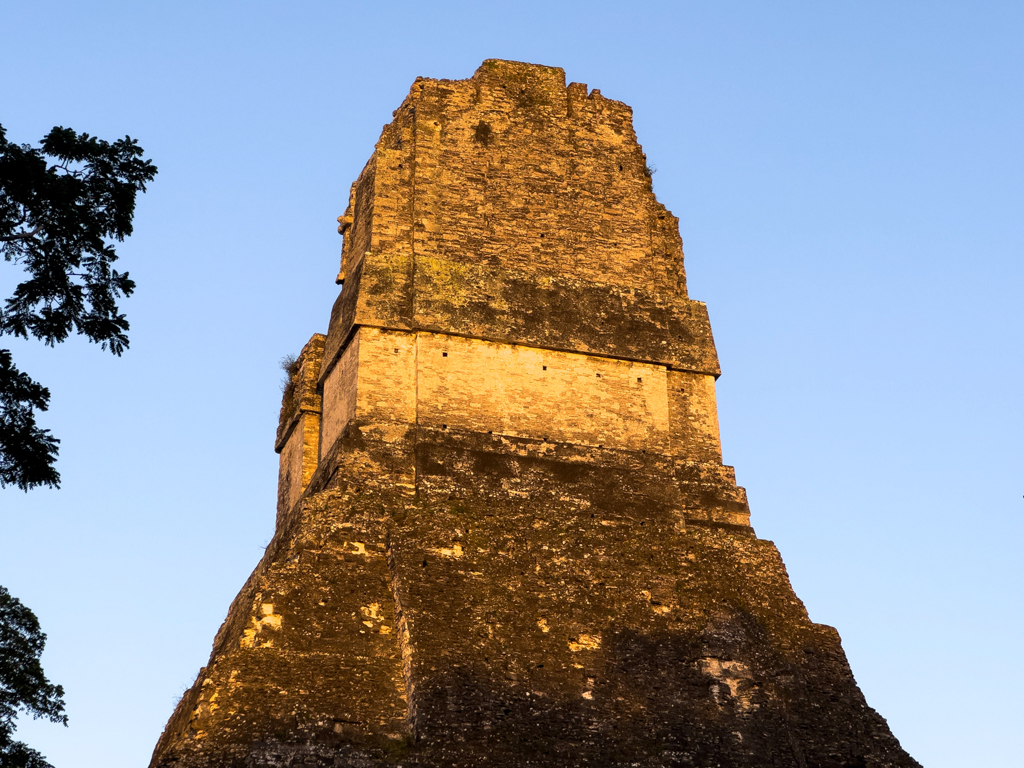 Sonnenstrahlen beleuchten die erste im Dschungel sichtbare Pyramide in Tikal