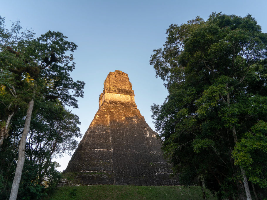 Sonnenstrahlen beleuchten die erste im Dschungel sichtbare Pyramide in Tikal