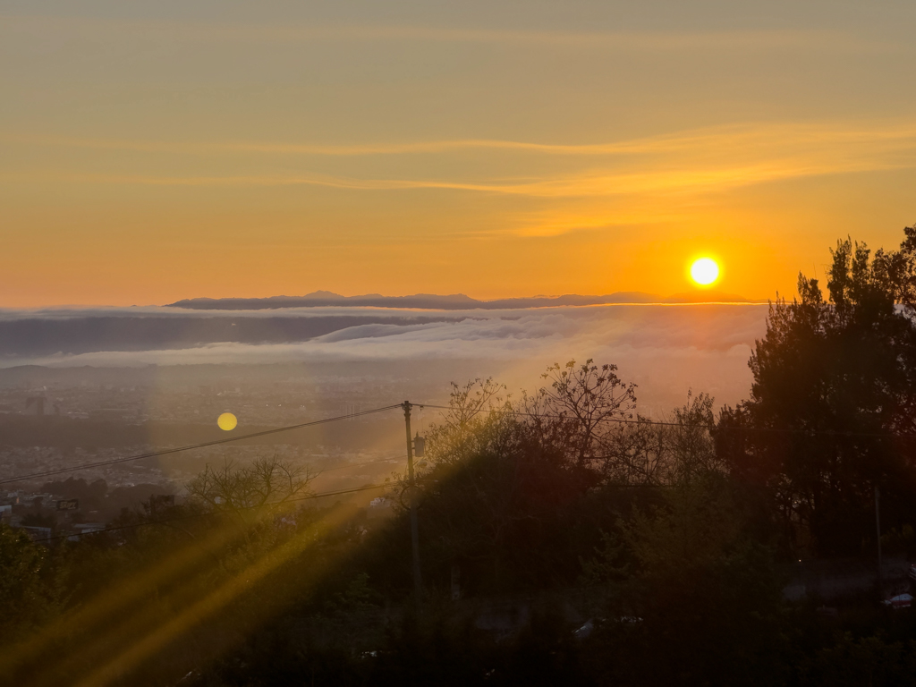 Sonnenaufgang. Noch liegt der Morgennebel über der Stadt