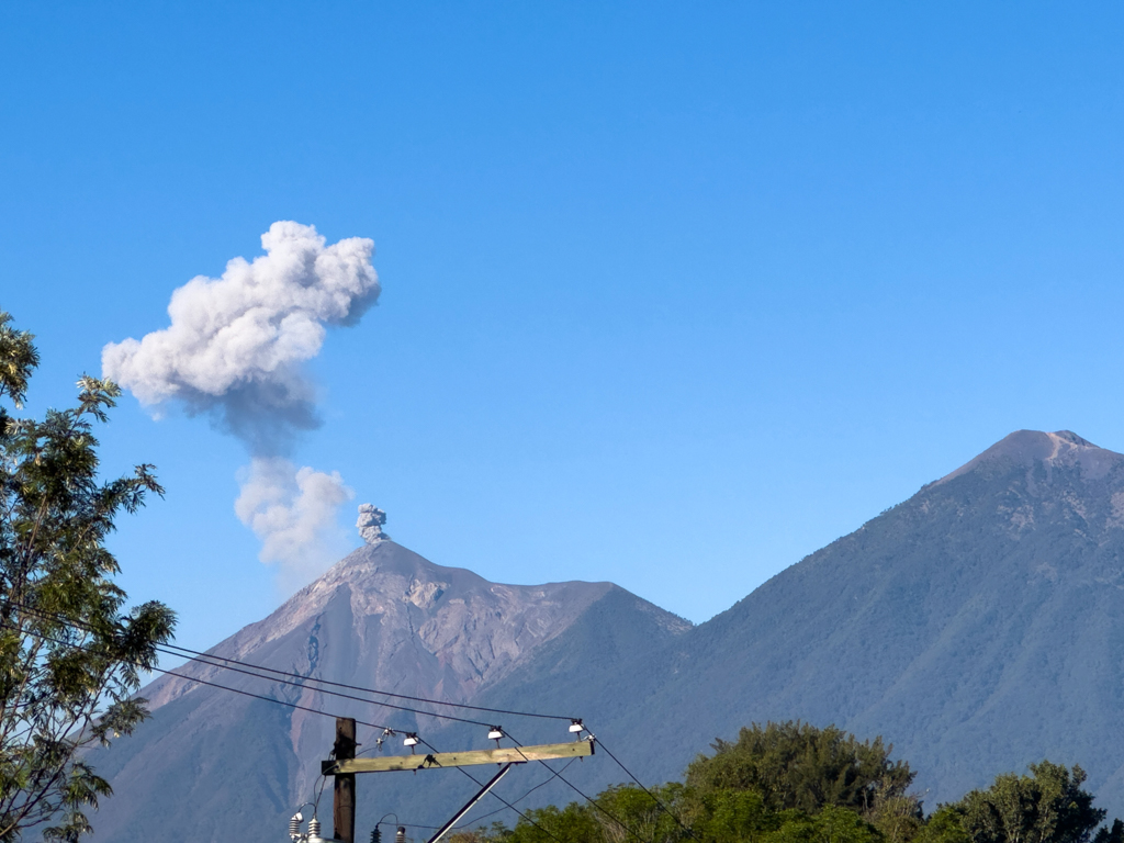 Fuego lässt seine Muskeln spielen und schickt ein Zeichen in den Himmel. Rechts der Acatenango, den wir heute besteigen werden.