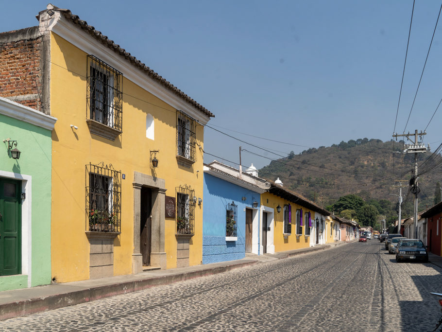 Buntes Strassenbild mit dem typischen Natursteinpflaster hier in Antigua
