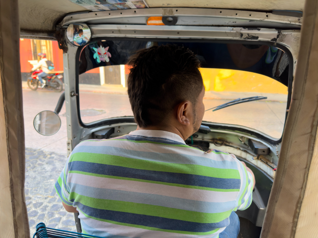 Unser rasender Tuck-Tuck Fahrer mit seinem kleinen Maskottchen an der Scheibe.