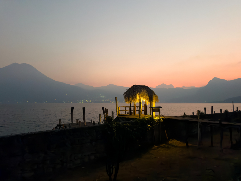 kleines Sonnenuntergangs Pano mit beleuchtetem Bootssteg über Lago Atitlán