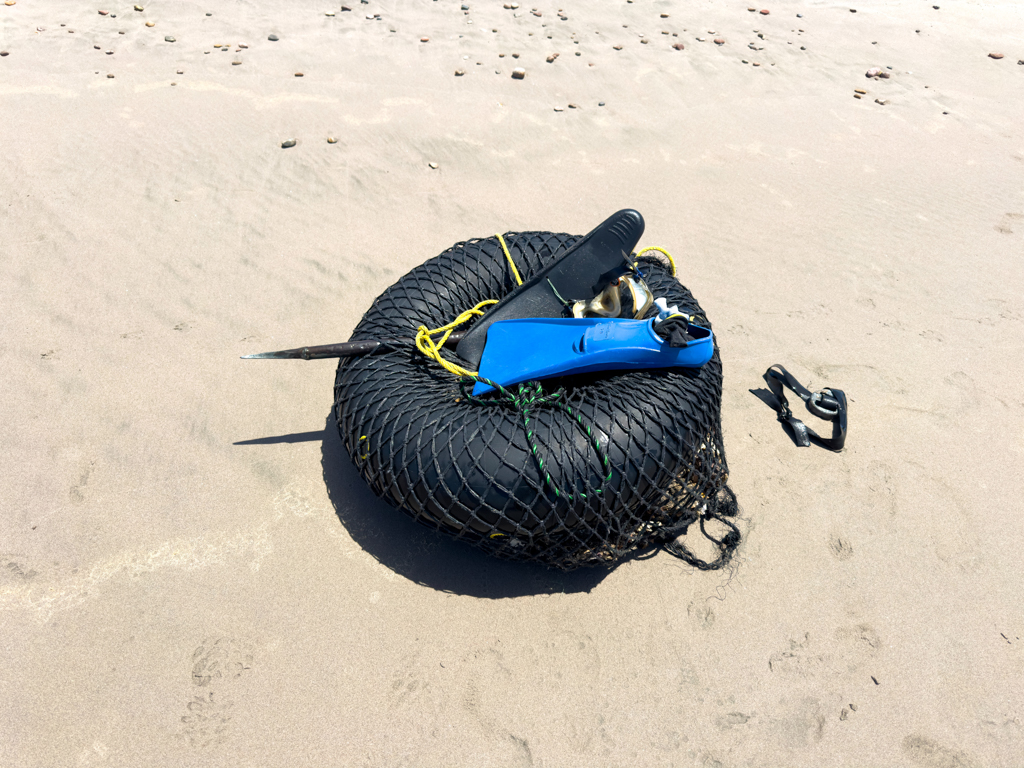 Die Ausbeute zweier Austernfischer. Schwimmreifen mit Beutenetz und Abbrech Werkzeug der Muscheln