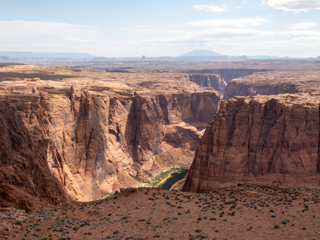 Ein überwältigender Ausblick von oben auf dem Spencer Trail. Vorne der tiefe Grand Canyon, hinten das Monument Valley
