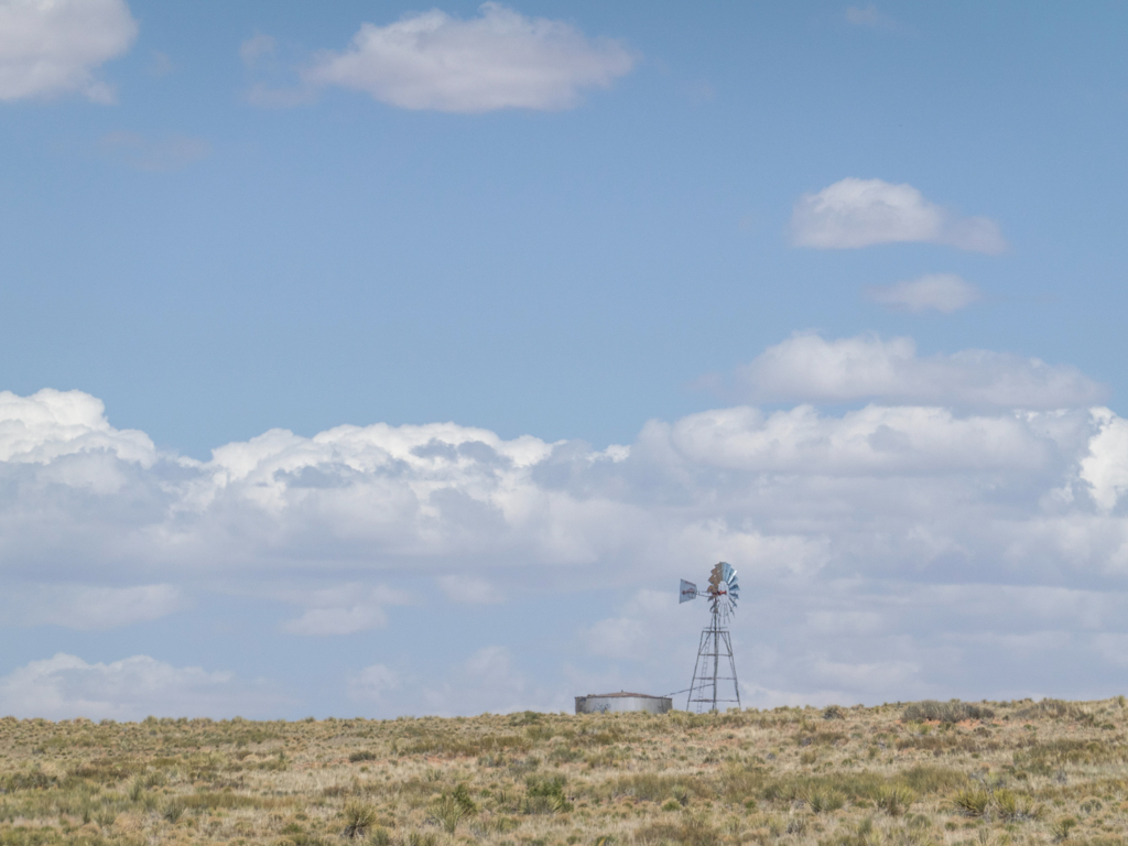 Einsames Windrad mit Kornspeicher im trockenen Land von Arizona