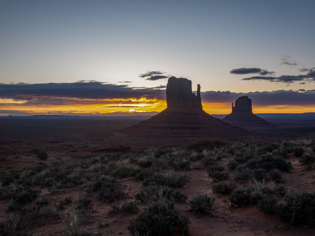 Der noch junge und dunkle Morgen am Monument Valley mit Sonnenaufgang am Horizont