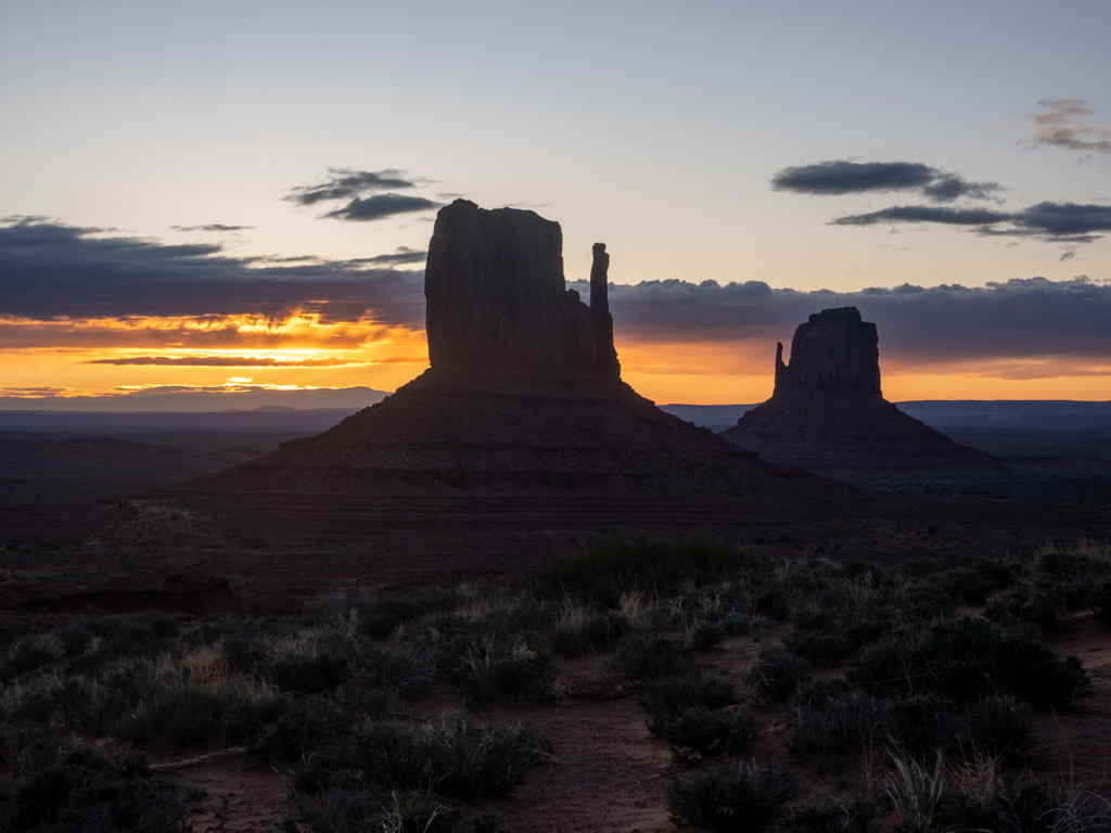 Der noch junge und dunkle Morgen am Monument Valley mit Sonnenaufgang am Horizont