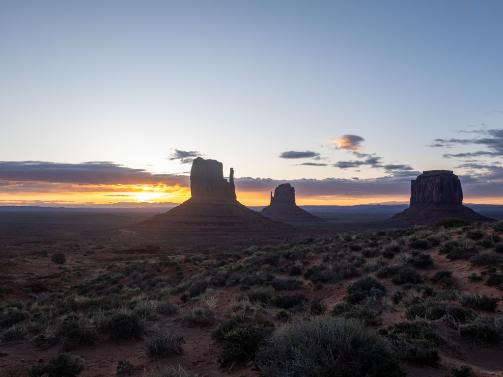 Der noch junge und dunkle Morgen am Monument Valley mit Sonnenaufgang am Horizont