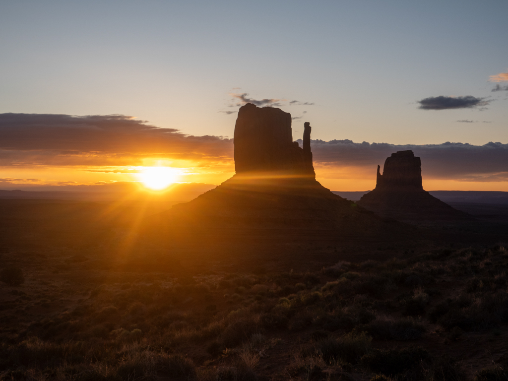 Der noch junge und dunkle Morgen am Monument Valley mit Sonnenaufgang am Horizont