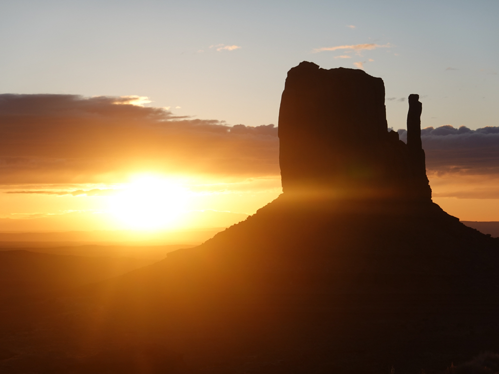 Der noch junge und dunkle Morgen am Monument Valley mit Sonnenaufgang am Horizont