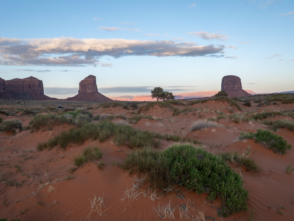 Hinter uns im Monument Valley sehen wir die Sonne aufgehen