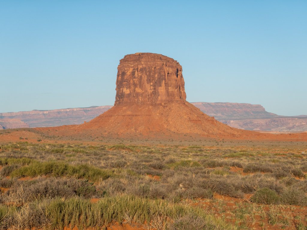 Hinter uns im Monument Valley sehen wir die Sonne aufgehen