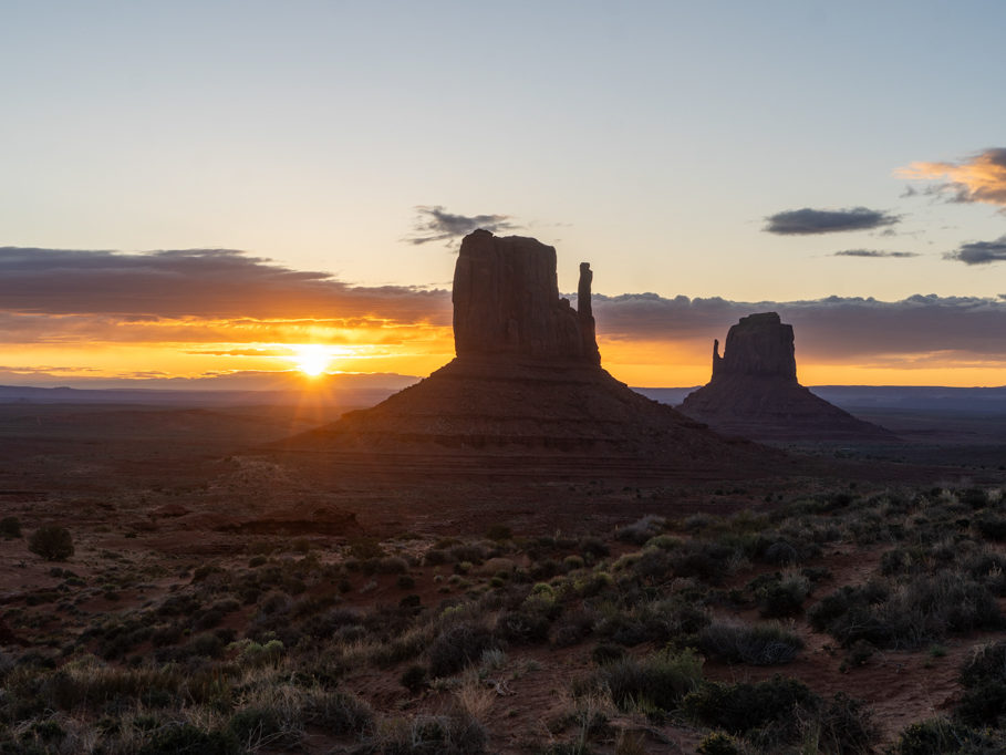 Der noch junge und dunkle Morgen am Monument Valley mit Sonnenaufgang am Horizont