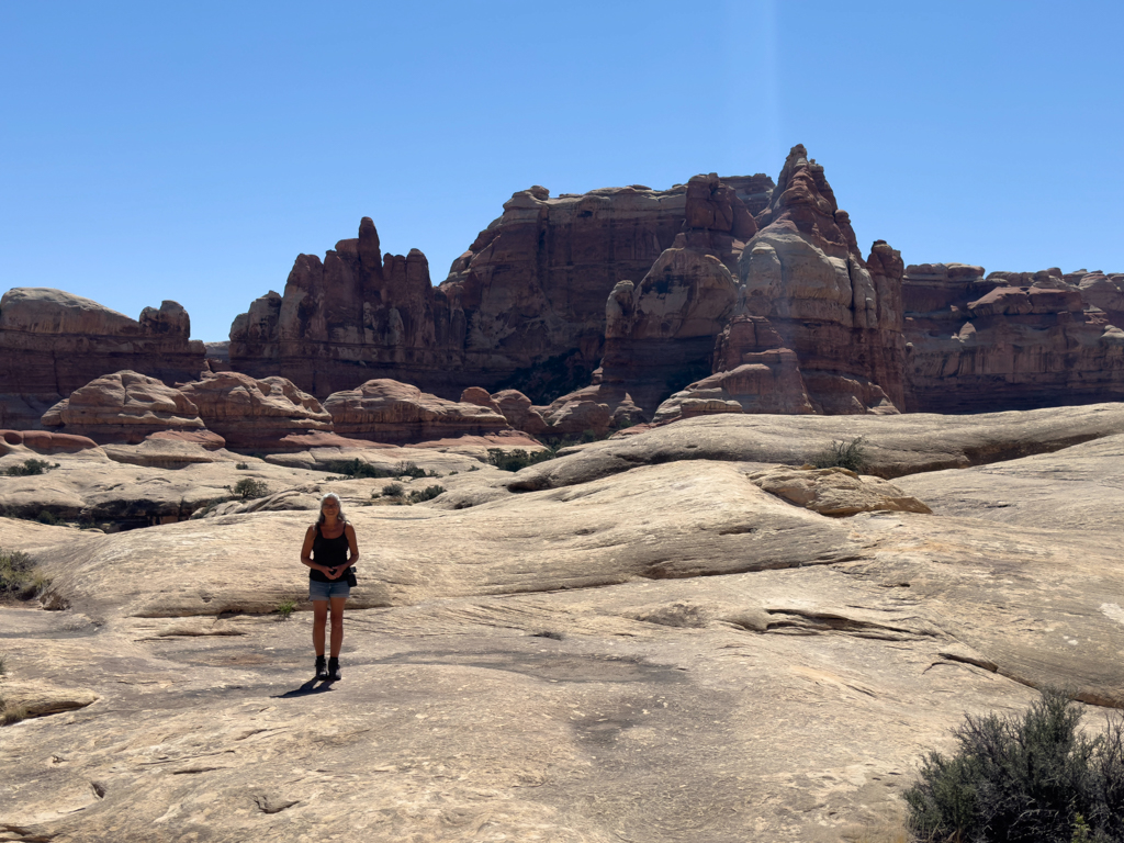 Wir wandern durch den beeindruckenden Needles NP. Ma posiert auf einem grossen Fels Plateau