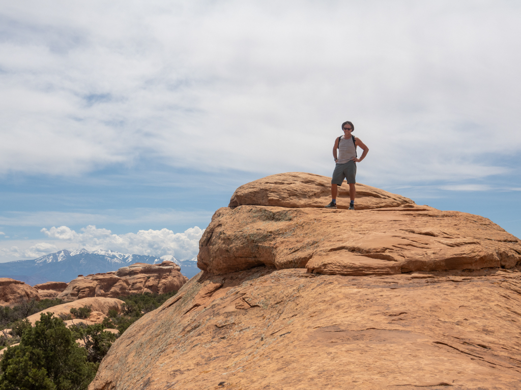 Jo posiert auf einem Felsrücken während der Wanderung im Arches NP