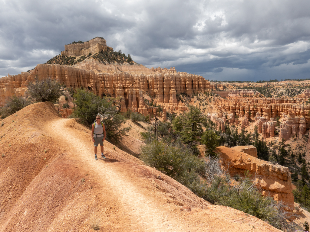 Mit Jo auf der Wanderung und mit Blick über die Landschaft im Bryce Canyon mit aufziehenden Regenwolken am Himmel