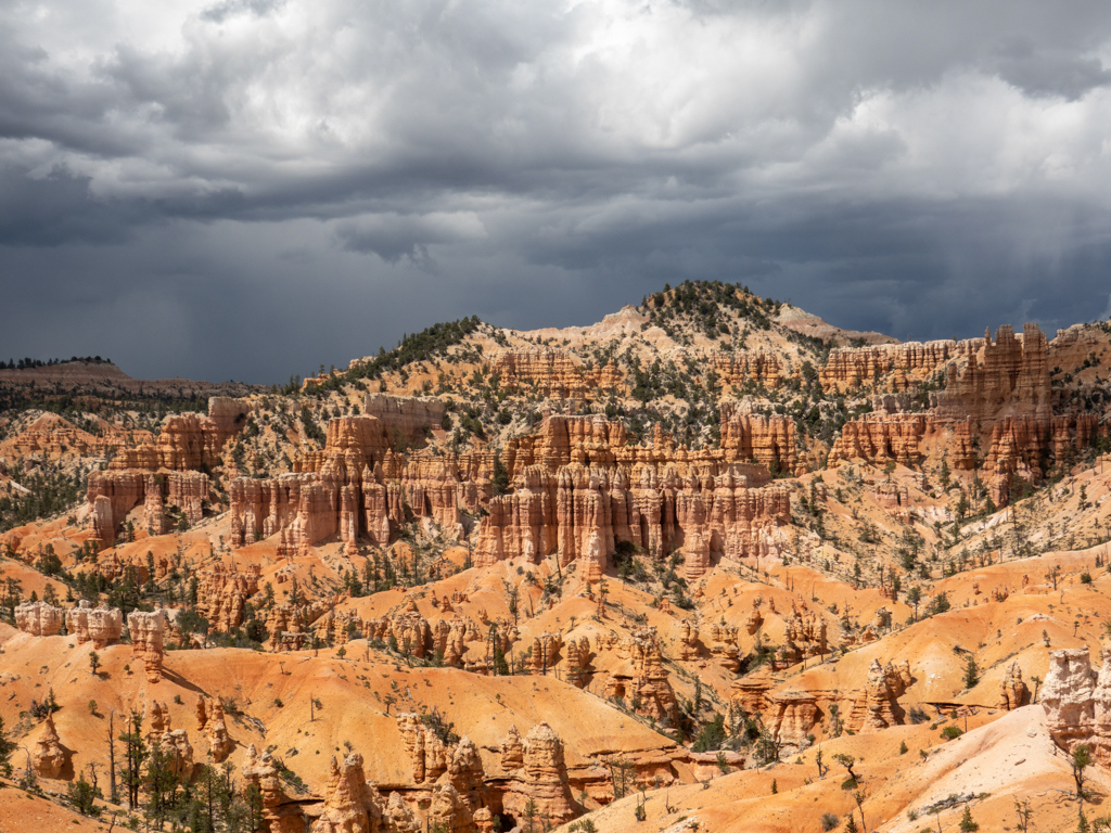 Blick über die Landschaft im Bryce Canyon mit aufziehenden dunklen Regenwolken am Himmel