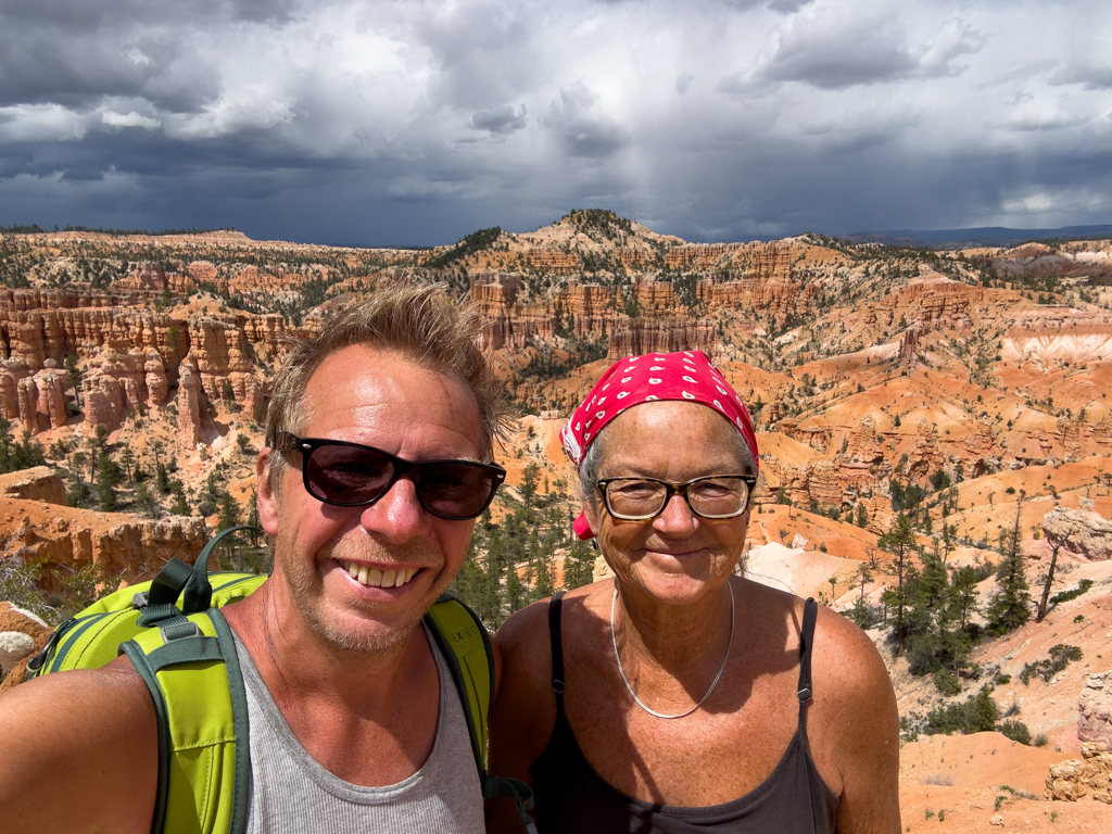 JoMa Selfie mit Blick über die Landschaft im Bryce Canyon mit aufziehenden Regenwolken am Himmel