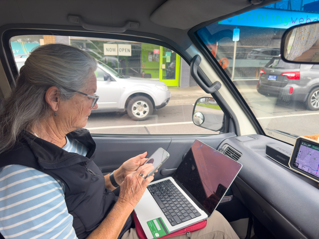 Während wir vor Melbounre auf einem Parkplatz stehen installiert Ma Linkt die App für die Tall Roads der Stadt