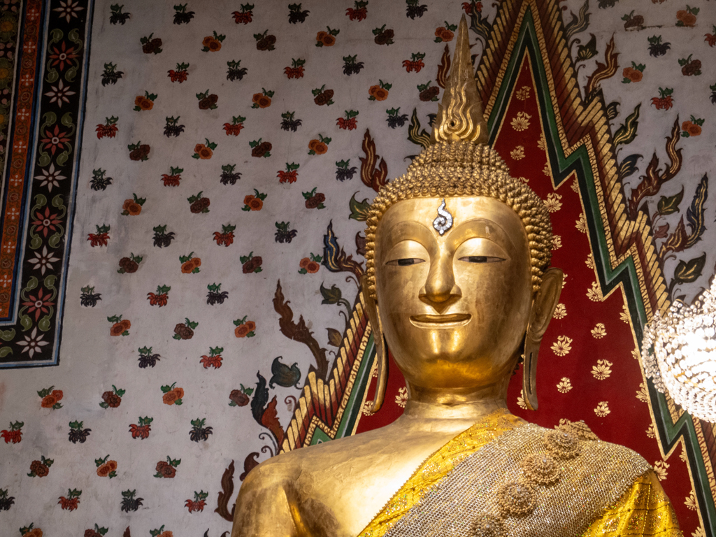Ein geschmückter Buddha in einem kleineren Schrein im Wat Arun Tempel