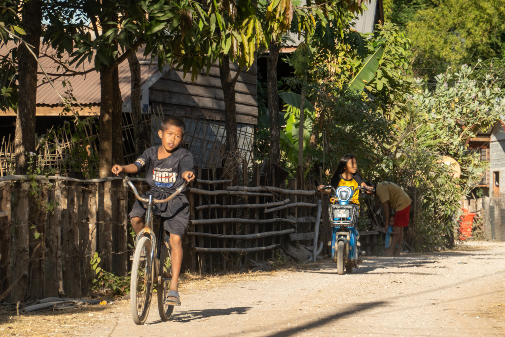 im Dorf am Resort sind Kinder mit Velo und Elektro Roller unterwegs