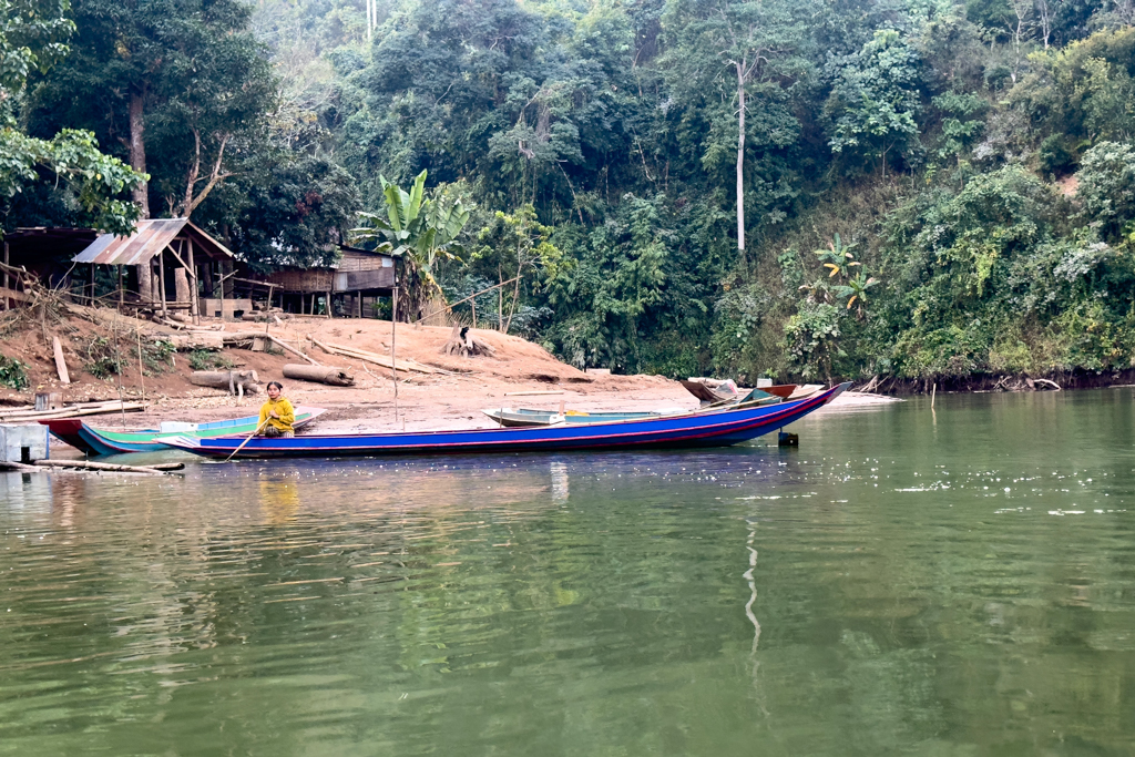 Eine Laotin rudert ihr Boot sicher ans Ufer